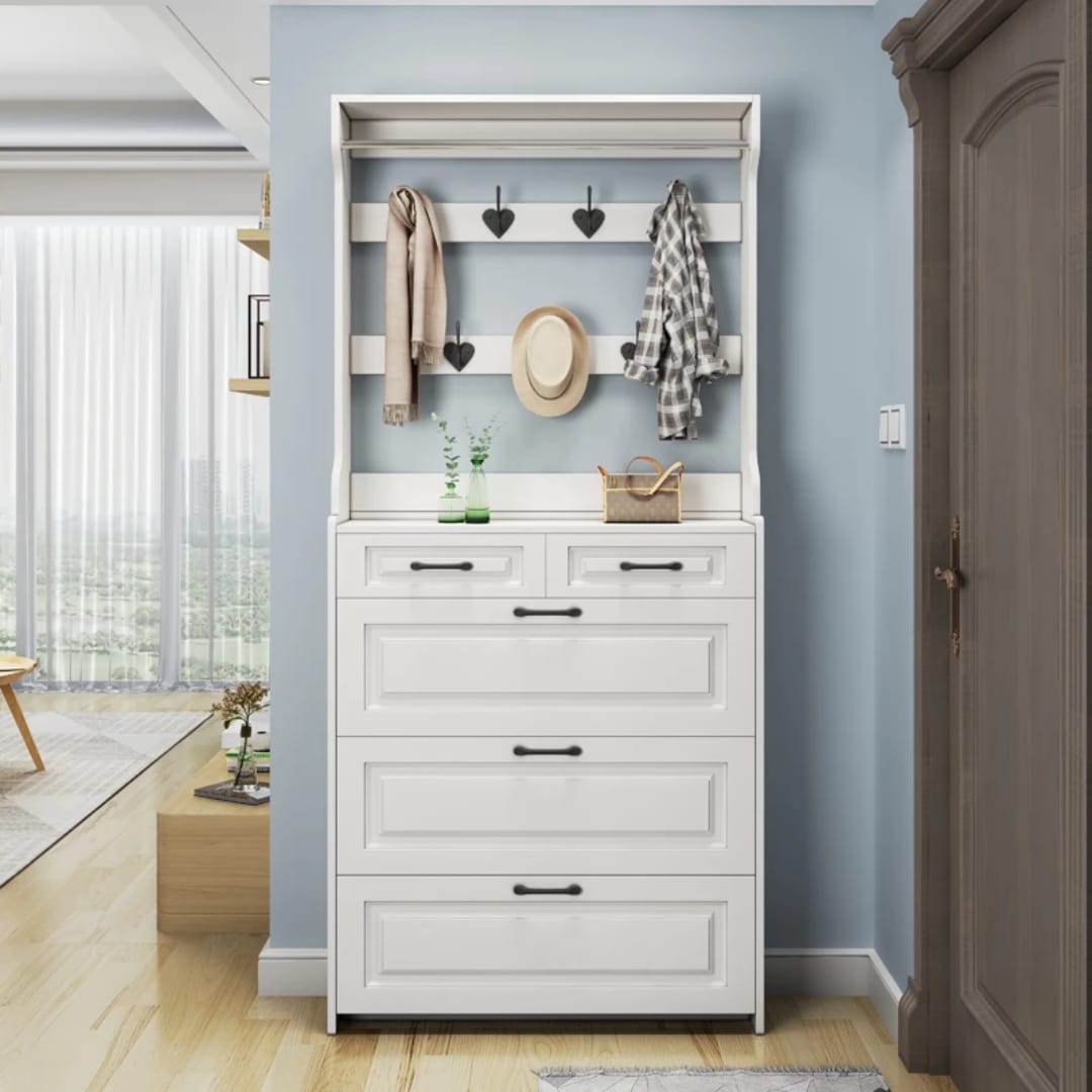 White hallway shoe and coat rack with black handles, hanging hooks and closed shoe compartments in a narrow entryway.
