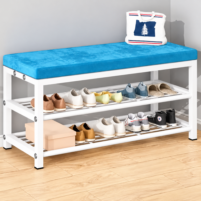 White and Blue Variant: White metal entryway shoe storage cabinet with a blue padded cushion seat and two open shoe shelves, displaying shoes in a home entryway.