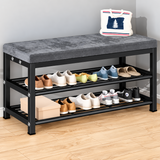Black and Grey Variant: Black metal shoe storage cabinet with a grey padded cushion seat and two open shoe shelves, displaying assorted footwear in a home entryway.