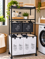 Black metallic laundry storage rack with perforated plastic top shelf, two black canvas baskets and two white lower laundry compartments.