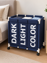 Navy blue  laundry basket with three labelled compartments and four wheels.